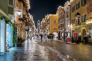 Sterzing Prints: Night view of the main street and Zwolferturm medieval tower decorated with Christmas lights