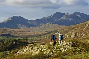 North Wales, Snowdonia. A man and woman stop to look at their map whilst hiking in Snowdonia