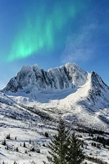 Breidtinden Prints: Northern Lights over Breidtinden mountain peak covered with snow