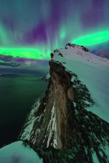 Aurora Borealis Prints: Northern Lights over the frozen sea view from a snowy ridge of Hesten mountain