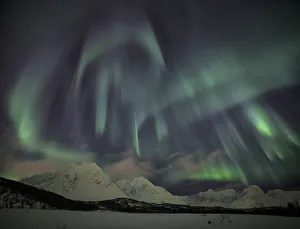 The Northern Lights illuminates the snowy landscape in Svensby Lyngen Alps TromsaAA¸ The Northern Lights illuminates the snowy landscape in Svensby Lyngen Alps TromsaAA¸