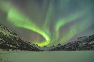 Nordland County Prints: Northern lights with mountains and three people in winter. Kleppstad, Nordland county