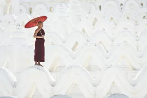 Images Dated 23rd April 2020: Novice monk with an umbrella standing at white Hsinbyume pagoda