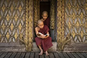 Images Dated 23rd April 2020: Two novice monks reading a book at a monastery, Mandalay, Mandalay District