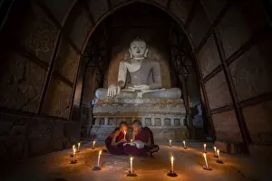 Two People Prints: Two novice monks studying inside a temple under big Buddha statue, UNESCO, Bagan