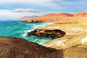 Rippled Prints: Ocean waves crashing on Playa De Garcey beach surrounded by volcanic cliffs