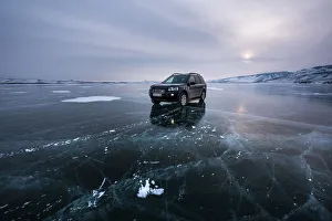 Irkutsk Region Prints: An offroad car over a flat ice at the lake Baikal, Irkutsk region, Siberia, Russia