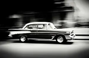 Classic Prints: Old American car speeding along The Malecon (waterfront) Havana Centro