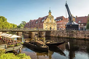 Luneburg Prints: Old barges on the Ilmenau with old department store, Luneburg, Lower Saxony, Germany