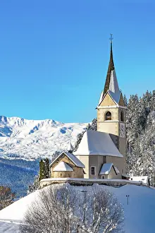 Old bell tower and church with snowcapped mountains on background, Alvaneu, Davos, Graubunden canton, Switzerland
