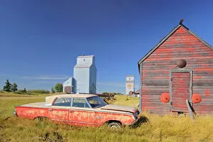 Prairie Sentinel Collection: Old car, grain elevator and sheds Darcy Saskatchewan, Canada