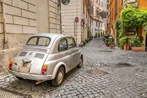 Automobile Prints: Old classic Fiat 500 car parked in a cobbled street of Rome, Lazio, Italy