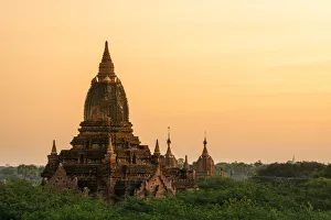 Stupas Prints: Old pagoda amidst trees against orange sky during sunrise, Bagan, Mandalay Region
