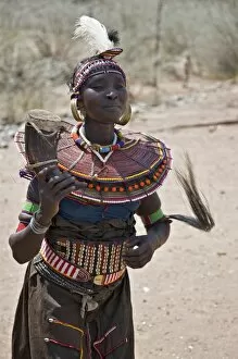 East Pokot District Collection: An old Pokot woman dancing during an Atelo ceremony. The cow horn container usually contains