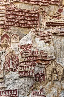 Shrine Collection: Old temple with Buddhas statues and religious carving on limestone rock in sacred Kaw