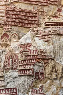 Praying Prints: Old temple with Buddhas statues and religious carving on limestone rock in sacred Kaw