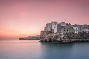 Old town of Polignano a Mare built on rocky cliffs at sunrise, Bari province, Apulia