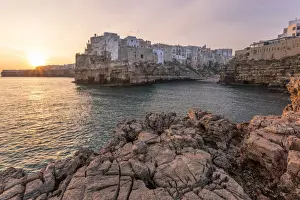 Old town of Polignano a Mare built on rocky cliffs at sunrise, Bari province, Apulia