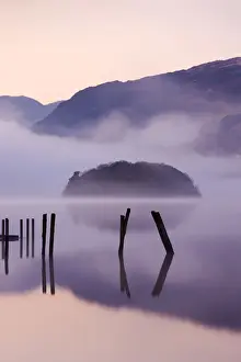 Serene Landscape Prints: Old wooden jetty and St Herberts Island on Derwent Water at dawn on a misty