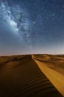 Oman Collection: Oman, Wahiba Sands. The sand dunes at night lit by the moon with the milky way
