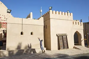 An Omani boy jumps to catch a ball in Bahla Fort, Tanuf, Oman