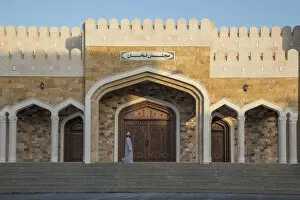 Islamic Architecture Collection: An Omani man walks in front of an ornate house in the village of Nakhal, Al-Batinah