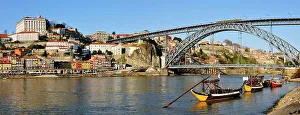 Oporto, capital of the Port wine and the Douro river. The bridge Dom Luis, a UNESCO World Heritage Site. In the foreground the traditional boats called Rabelos'. Portugal