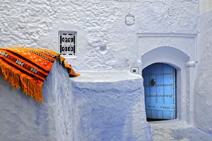 Chefchaouen Prints: Orange blanket in the bluish Chefchaouen medina. Morocco
