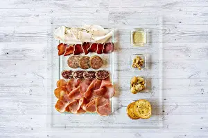 Plate Prints: Overhead view of mixed cold cuts in glass serving plate with croutons as appetizer