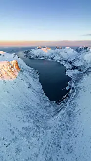 Mountain Road Prints: Overhead view of a snowy mountain road leading to Bergsfjord village overlooking the icy sea