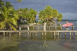 Images Dated 28th March 2008: Panama, Bocas del Toro Province, Carenero Island (Isla Carenero), Surfer walks along