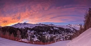 Panorama of the alpine village of Madesimo and snowy ski slopes at sunset Spluga
