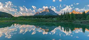Panorama of Canadian Rocky Mountains reflected in a pond in the Silverhorne Creek Campground. Icefields Parkway. Possibly Mount Patterson in centre and Capricorn Mountain at right. Banff National Park, Alberta, Canada