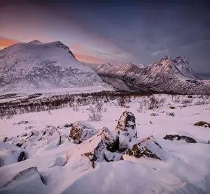 Norwegian Sea Prints: Panorama of snowy peaks surrounded by frozen sea under orange clouds at sunset