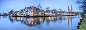 Panorama of typical houses and towers of cathedral reflected in river Trave at dusk Panorama of typical houses and towers of cathedral reflected in river Trave at dusk