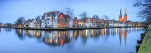 City Centre Prints: Panorama of typical houses and towers of cathedral reflected in river Trave at dusk
