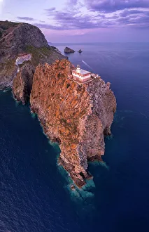 Tyrrhenian Prints: Panoramic aerial view of the lighthouse on top of a rocky cliff at dusk