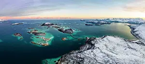 High Up Prints: Panoramic aerial view of Sommaroy island in between snowy mountains and frozen sea at dawn