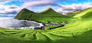 Denmark Prints: Panoramic of the coastal village of Gjogv on grass covered cliffs overlooking the ocean at dawn