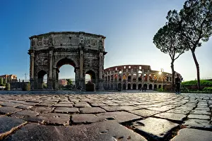 Triumphal Arch Prints: Panoramic of Coliseum and Arch of Constantine lit by sun rays at dawn, Rome, Italy