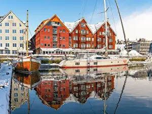 Panoramic of multicolored houses and harbor reflected in the sea at dawn, Tromso, Norway