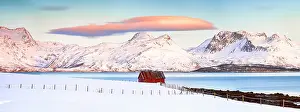 Fjord Prints: Panoramic of snowcapped mountains and traditional red cabin by a fjord at sunrise