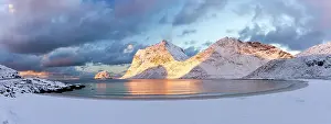 Finish Prints: Panoramic of the snowy Haukland beach and mountains under colorful clouds at dawn