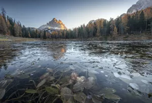 The partially frozen Antorno lake and the Tre Cime di Lavaredo during a cold autumn morning, in the Italian Dolomites