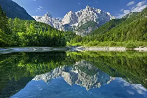 Peaks of Prisojnik and Razor reflected in pools beside the Velika Pisnca River in summer