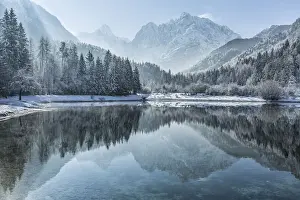 Peaks of Prisojnik and Razor reflected in pools beside the Velika Pisnca River in winter