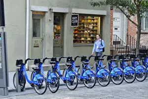 Bicycles Prints: Pedestrian walking past a rack of Citi Bikes on Spring street, in Soho, Manhattan
