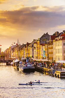 Canal Gallery: Two people kayaking in the Nyhavn canal in Copenhagen at sunset, Denmark