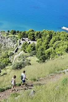 People walking at cliff La Rocca, Cefalu, Sicily, Italy, Europe