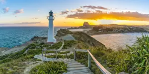 People watching the sun setting down behind Castle Rock and Castlepoint lighthouse